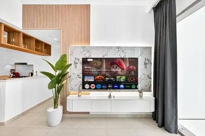 a living room with a tv on a wall at Golden Stays - Stunning Downtown 2Br with Full Burj Views & Free Parking in Dubai