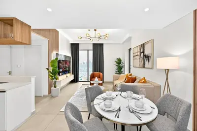 a kitchen and living room with a table and chairs at Golden Stays - Stunning Downtown 2Br with Full Burj Views & Free Parking in Dubai