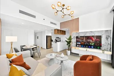 a living room with a couch and a tv at Golden Stays - Stunning Downtown 2Br with Full Burj Views & Free Parking in Dubai