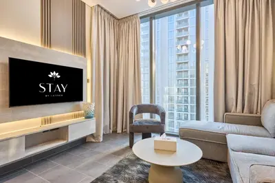 a living room with a couch and a tv at STAY BY LATINEM Luxury 1BR Holiday Home CC 3007 Near Burj Khalifa in Dubai