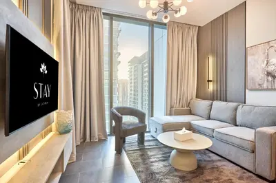 a living room with a couch and a tv at STAY BY LATINEM Luxury 1BR Holiday Home CC 3007 Near Burj Khalifa in Dubai