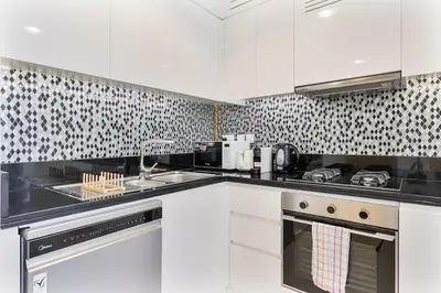 a kitchen with white cabinets and black and white wallpaper at Modern 2Bed with Canal Views 7 Mins to Burj Khalifa in Dubai