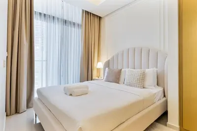 a bedroom with a white bed with a large window at Modern 2Bed with Canal Views 7 Mins to Burj Khalifa in Dubai