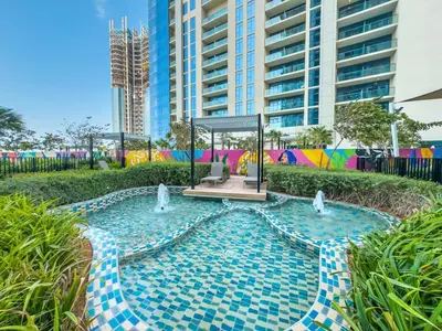 a swimming pool with fountains in front of a building at Modern 2Bed with Canal Views 7 Mins to Burj Khalifa in Dubai