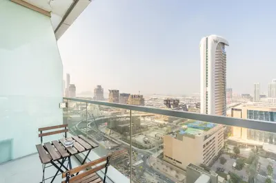 a balcony with two chairs and a view of a city at RH- Marina Living- Chic Ocean Heights 3BR with Panoramic Views in Dubai