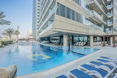 a large swimming pool in a building with lounge chairs at RH- Marina Living- Chic Ocean Heights 3BR with Panoramic Views in Dubai