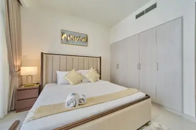 a bedroom with a bed with two towels on it at fam Living Chic 1BR Retreat in Dubai Hills Estate in Dubai