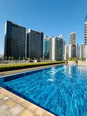 a swimming pool with a city skyline in the background at Mama's Crib Dubai in Sabkhah