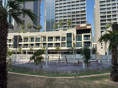 a building with trees in front of tall buildings at Mama's Crib Dubai in Sabkhah