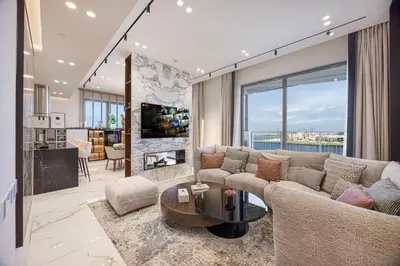 a living room with a couch and a table and a kitchen at Daniels 3BR at La Cote with Full Sea View in Dubai