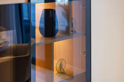 a glass shelf with a black vase on it at Daniels 3BR at La Cote with Full Sea View in Dubai