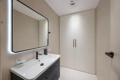a white bathroom with a sink and a mirror at Daniels 3BR at La Cote with Full Sea View in Dubai