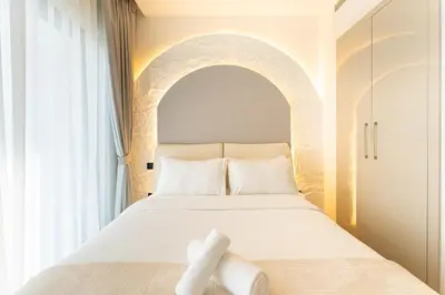 a bedroom with a white bed with an arch above it at HAVN - 1 bedroom in The Crest, Skyline Views in Dubai
