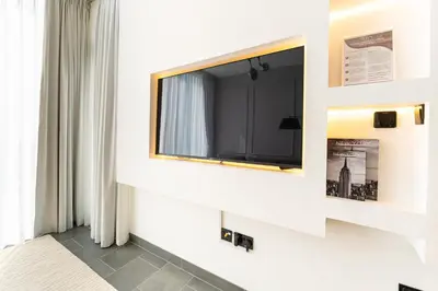 a flat screen tv on a wall in a room at HAVN - 1 bedroom in The Crest, Skyline Views in Dubai