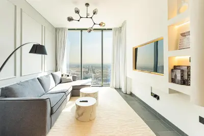 a living room with a couch and a large window at HAVN - 1 bedroom in The Crest, Skyline Views in Dubai