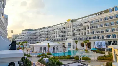 a large white building with a pool in front of it at Vincitore Benessere - Arjan by Golden Casa in Dubai