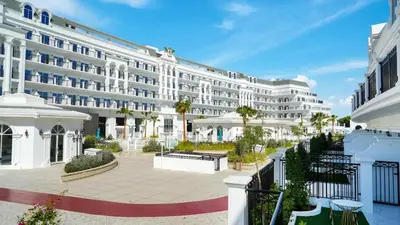 a large white building with a courtyard in front of it at Vincitore Benessere - Arjan by Golden Casa in Dubai