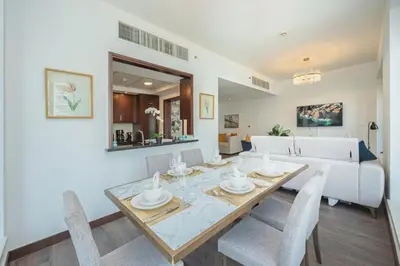a dining room and living room with a table and chairs at 2BR 29Blvd Balcony Fountain View in Dubai