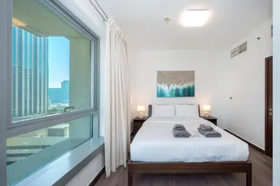a bedroom with a bed and a large window at 2BR 29Blvd Balcony Fountain View in Dubai