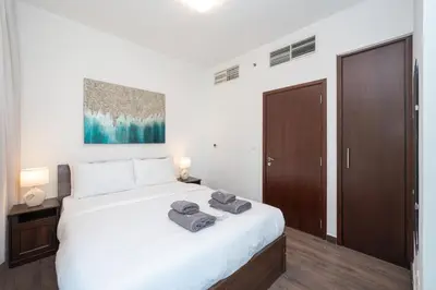 a bedroom with a large white bed with towels on it at 2BR 29Blvd Balcony Fountain View in Dubai