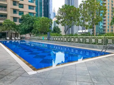 a large blue swimming pool in a city at 2BR 29Blvd Balcony Fountain View in Dubai