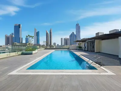 a swimming pool on the roof of a building with a city skyline at Modern 1BR Near World Trade Center Metro in Dubai