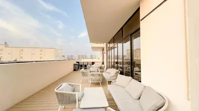 a balcony with white chairs and tables on a building at Escape24 Chic 1BR in Al Furjan near Metro in Dubai
