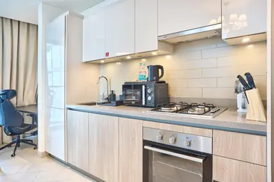 a kitchen with white cabinets and a stove top oven at STAY BY LATINEM Luxury 2BR Holiday Home W2013 near Downtown in Dubai