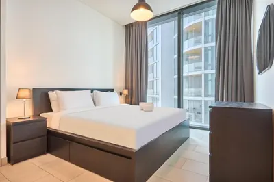 a bedroom with a bed and a large window at STAY BY LATINEM Luxury 2BR Holiday Home W2013 near Downtown in Dubai