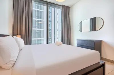 a bedroom with a large bed and a mirror at STAY BY LATINEM Luxury 2BR Holiday Home W2013 near Downtown in Dubai