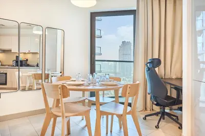 a dining room with a table and chairs and a window at STAY BY LATINEM Luxury 2BR Holiday Home W2013 near Downtown in Dubai