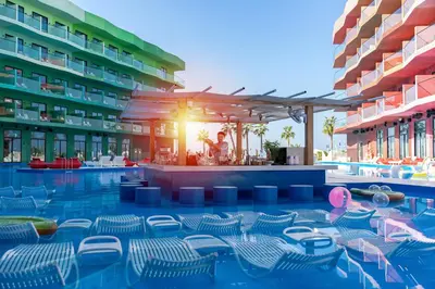 a resort with a pool with chairs and a bar at voco Dubai Nice The Heart of Europe by IHG in Dubai