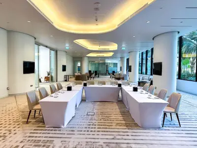 a meeting room with tables and chairs in a building at voco Dubai Nice The Heart of Europe by IHG in Dubai
