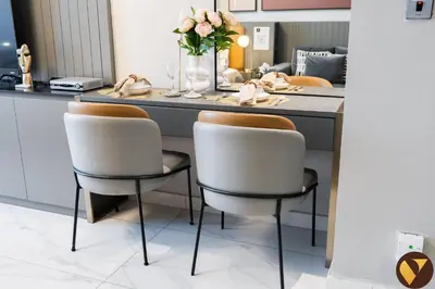 two chairs in front of a kitchen counter with flowers at Vogue Downtown Mag 318 near Burj Khalifa and Dubai Mall, Studio Apartment with Balcony and City View, Access to all Amenities in Dubai
