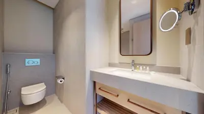 a bathroom with a sink and a toilet and a mirror at Vacationer l 2 Bed Direct Dubai Mall Access l Free Pool, Gym in Dubai