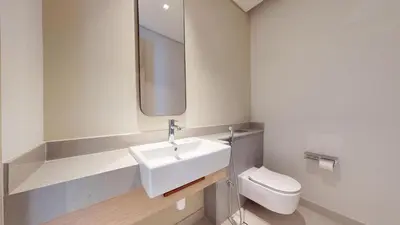a bathroom with a white sink and a toilet at Vacationer l 2 Bed Direct Dubai Mall Access l Free Pool, Gym in Dubai