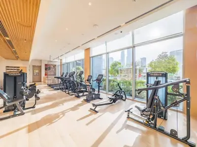 a gym with a row of treadmills and ellipticals at Vacationer l 2 Bed Direct Dubai Mall Access l Free Pool, Gym in Dubai