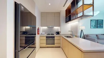 a kitchen with a sink and a refrigerator at Vacationer l 2 Bed Direct Dubai Mall Access l Free Pool, Gym in Dubai