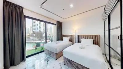 two beds in a hotel room with a large window at Vacationer l Lux 2 Bedroom Apartment with Marina & Skyline View Prime Location in Dubai