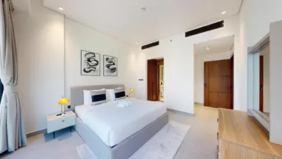 a white bedroom with a large white bed and a door at Vacationer I Premium 2 Bedroom Apartment I Close to DIFC & WTC I Central Location in Dubai