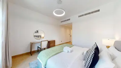 a white bedroom with a bed and a desk at Vacationer l Upgraded Chic 2 Bed l Pool View l Free Pool, Gym Access in Dubai