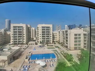 a view of a city with a pool and buildings at Vacationer l Upgraded Chic 2 Bed l Pool View l Free Pool, Gym Access in Dubai
