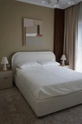 a bedroom with a large white bed with two lamps at Modern Apartment in JVC in Dubai