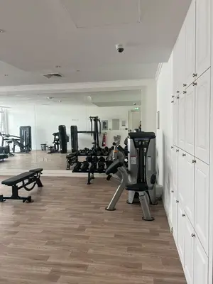 a gym with treadmills and machines in a room at Modern Apartment in JVC in Dubai