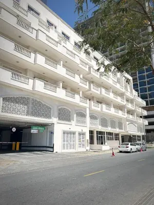 a white building with a car parked in front of it at Modern Apartment in JVC in Dubai