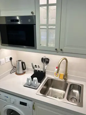 a kitchen counter with a sink and a microwave at Modern Apartment in JVC in Dubai