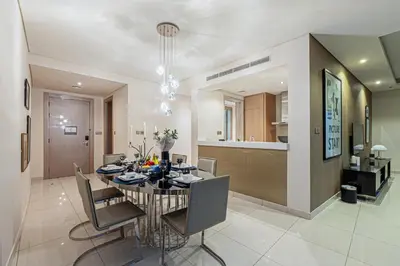 a dining room and kitchen with a table and chairs at Venetian - High Floor 2BR Residence with Incredible Burj View in Dubai