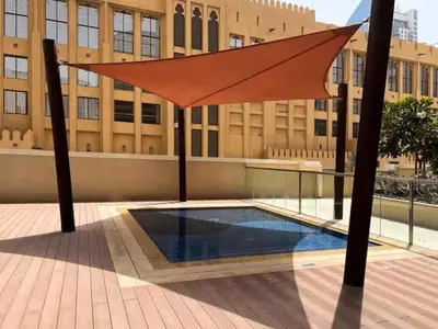 a large orange umbrella in front of a building at Vogue Downtown Bellevue Towers near Burj Khalifa and Dubai Mall, One Bedroom Apartment with City View, Full Access to all Amenities in Dubai
