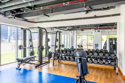 a gym with a lot of equipment in a room at Vogue Downtown Bellevue Towers near Burj Khalifa and Dubai Mall, One Bedroom Apartment with City View, Full Access to all Amenities in Dubai