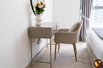 a vase of flowers on a table in a bedroom at Vogue Downtown Bellevue Towers near Burj Khalifa and Dubai Mall, One Bedroom Apartment with City View, Full Access to all Amenities in Dubai